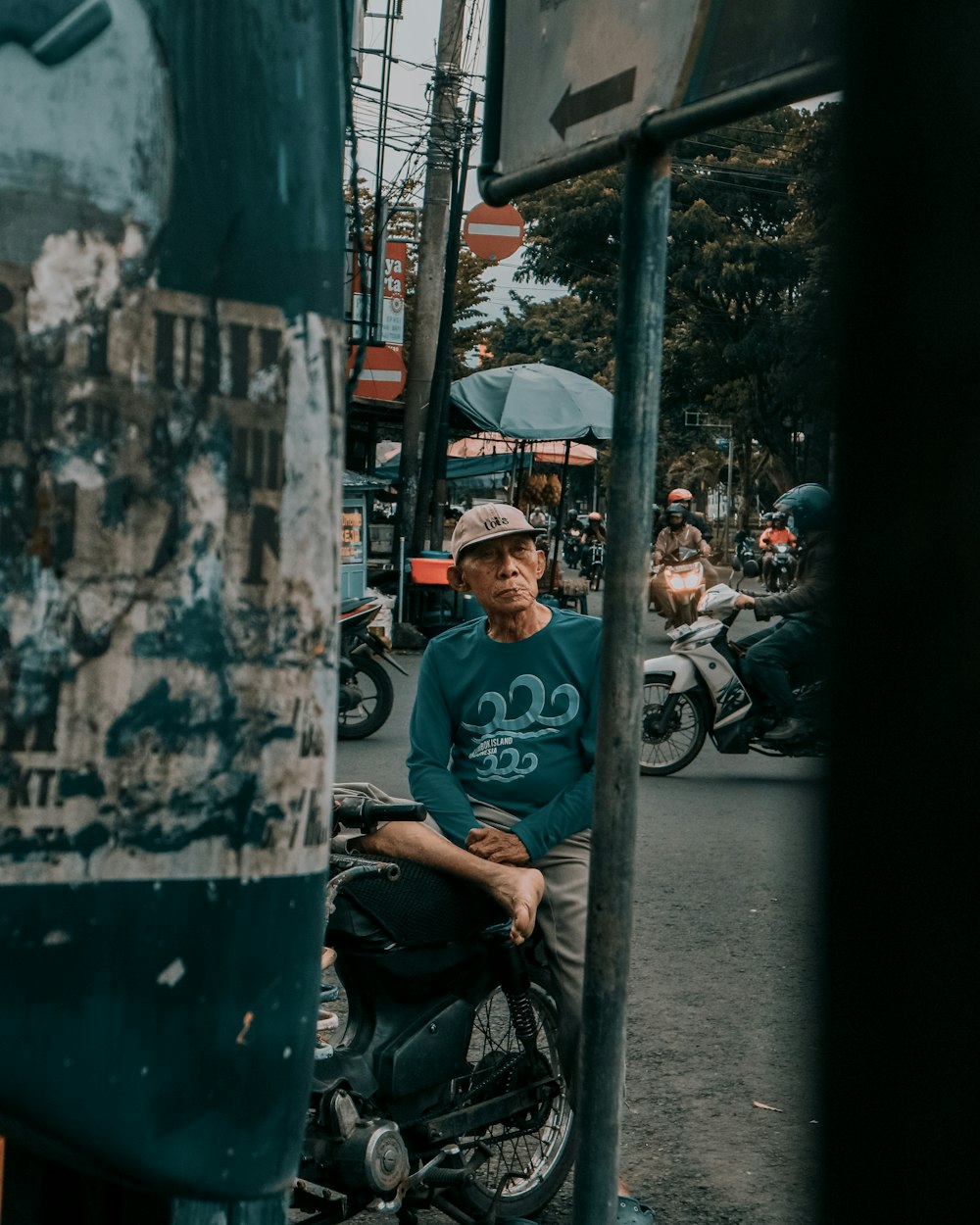 man in blue crew neck t-shirt and black pants sitting on black motorcycle during daytime