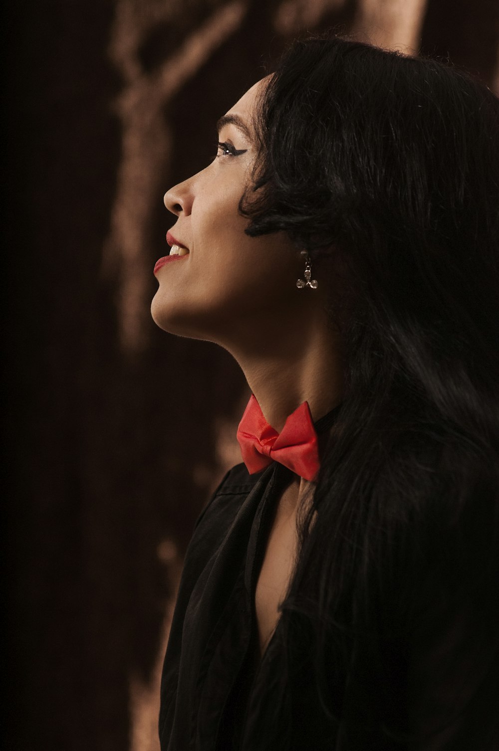 woman in black dress with red ribbon on her hair