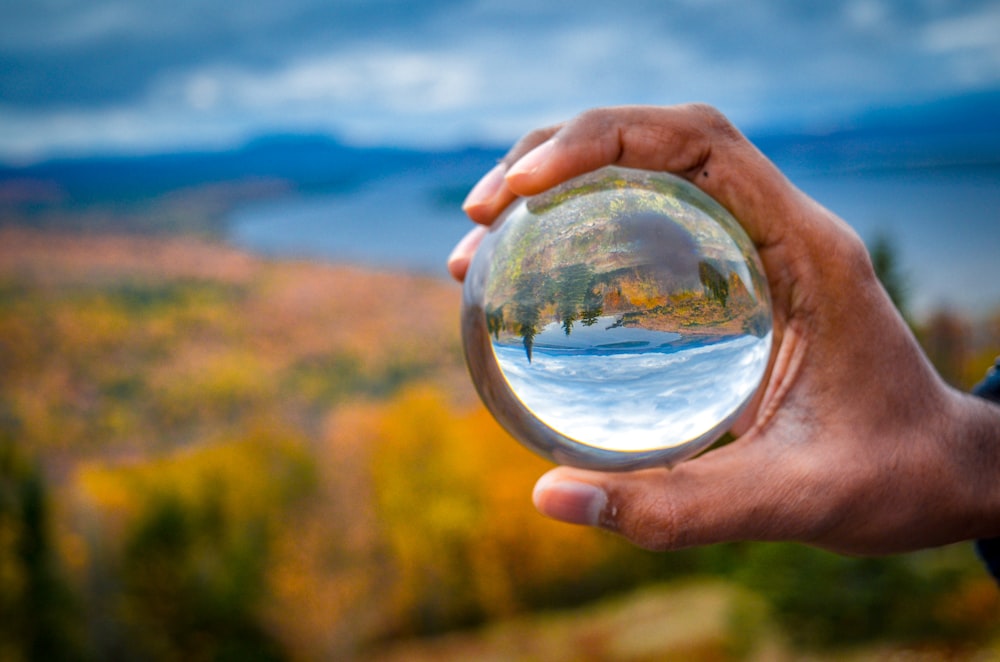 person holding clear glass ball