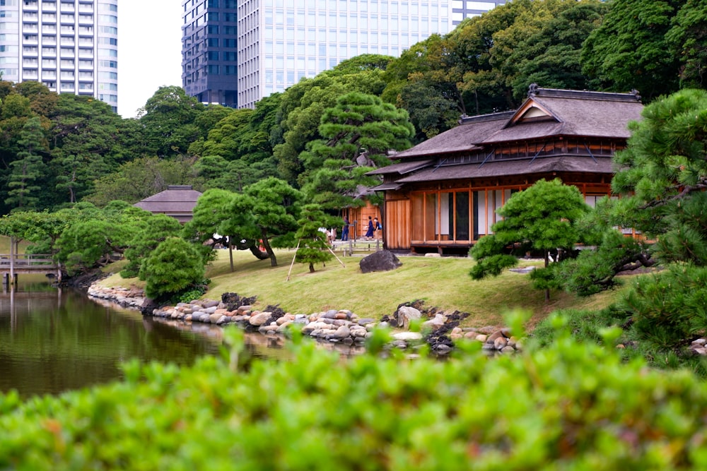 brown wooden house near green trees and river during daytime