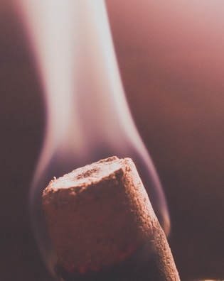 Close-up of ancient incense sticks burning with soft smoke curling upwards.