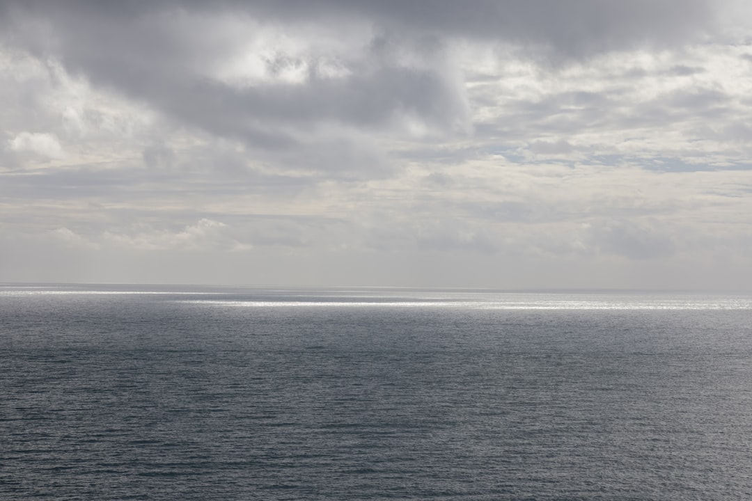 body of water under cloudy sky during daytime