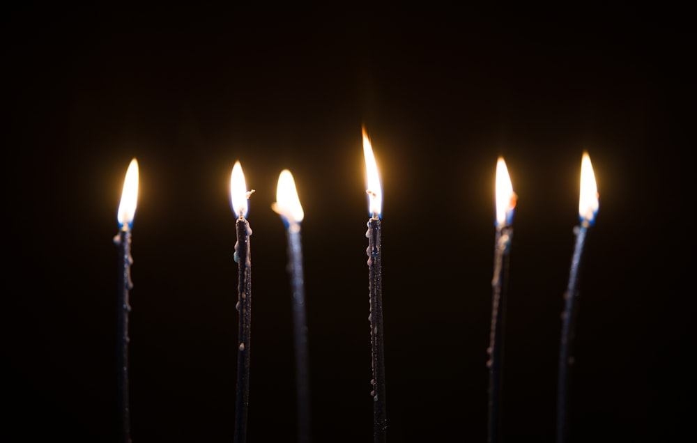 lighted candles on black metal sticks