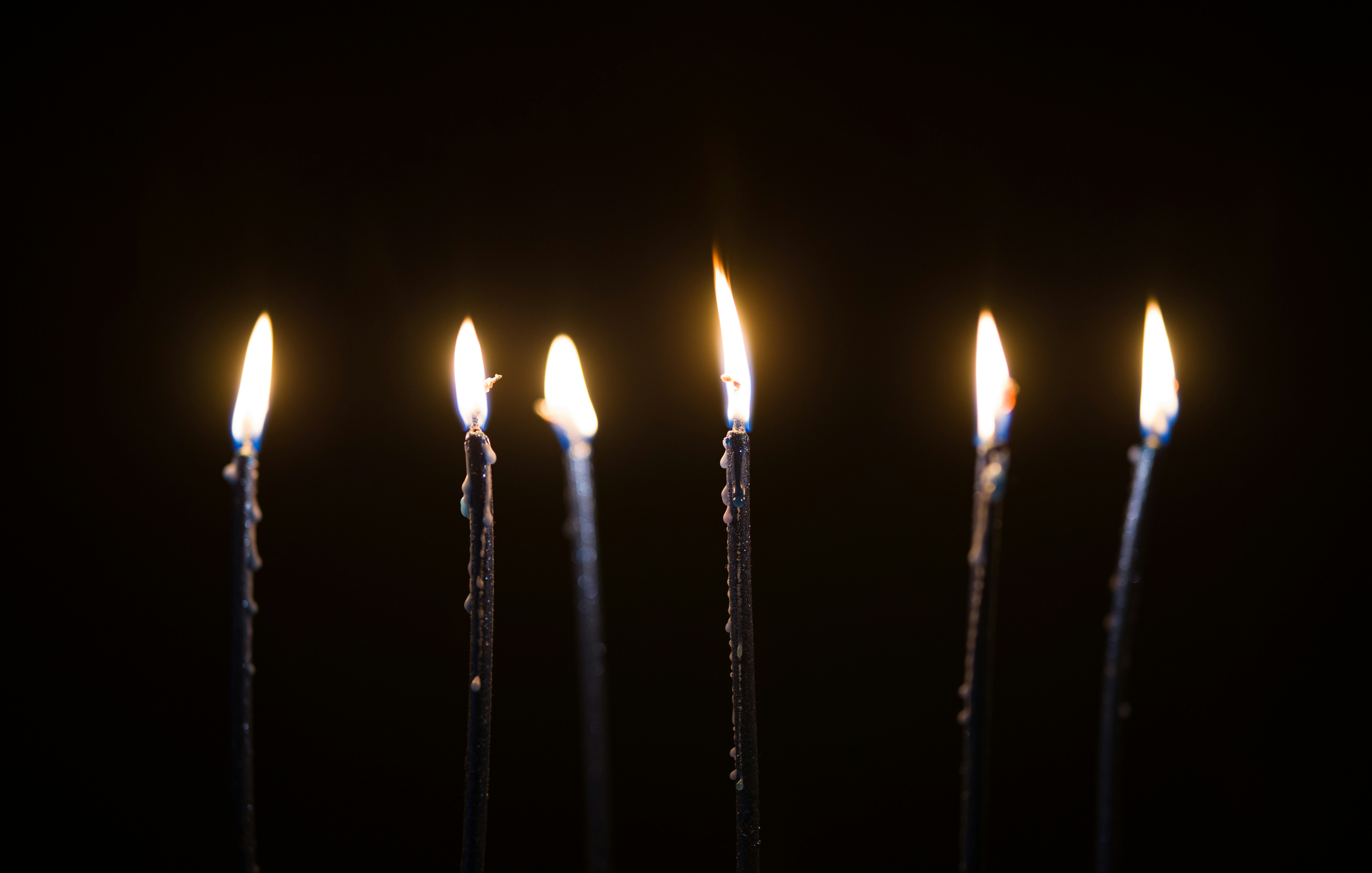 lighted candles on black metal sticks