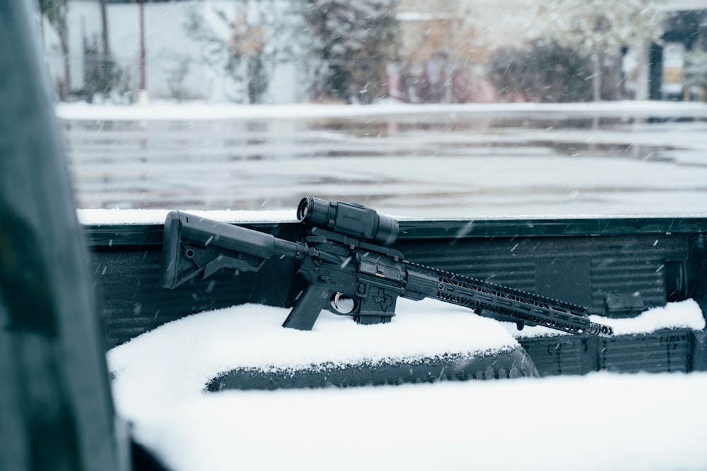 Rifle negro en suelo cubierto de nieve durante el día
