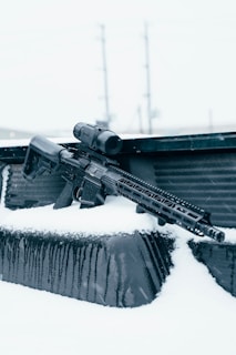 black assault rifle on snow covered ground