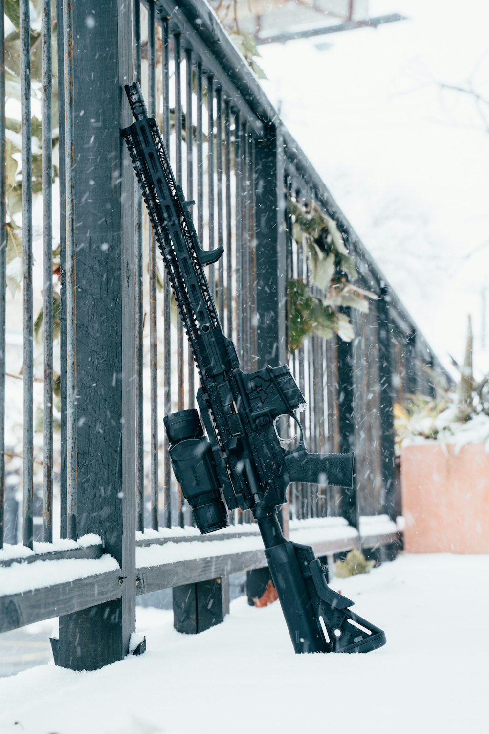 雪に覆われた地面に黒いライフル