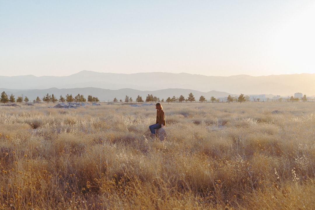 woman in black dress standing on brown grass field during daytime