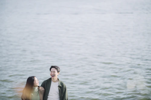 asian free dating site – couple smiling beside water