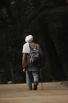 Elderly person confidently hiking with a Hypershell exoskeleton on a gentle forest path.