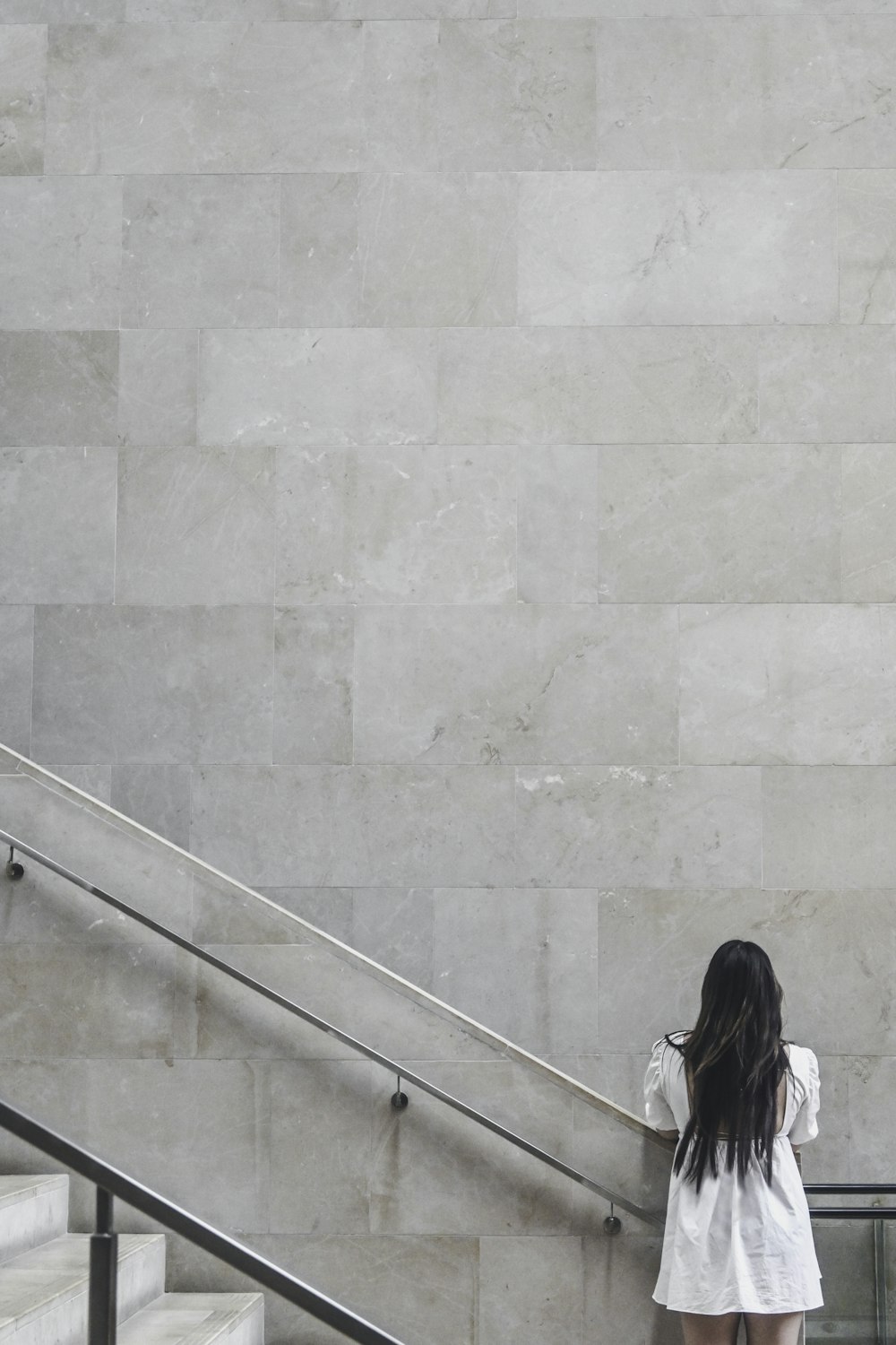 woman in black jacket sitting on concrete stairs