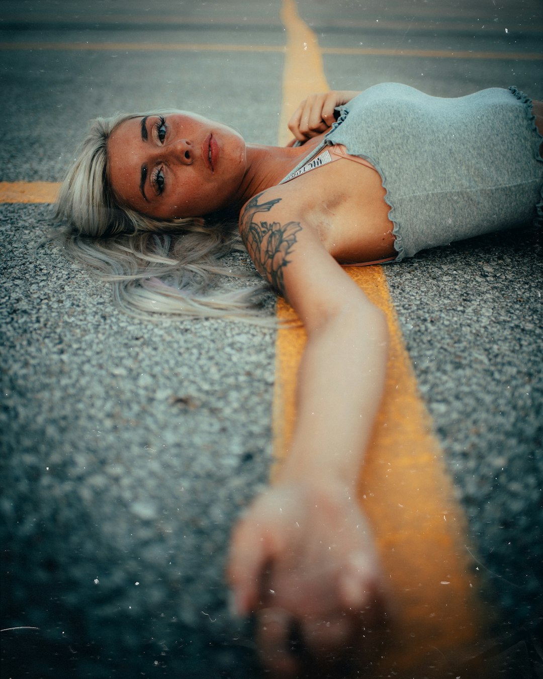 woman in gray tank top lying on gray concrete floor