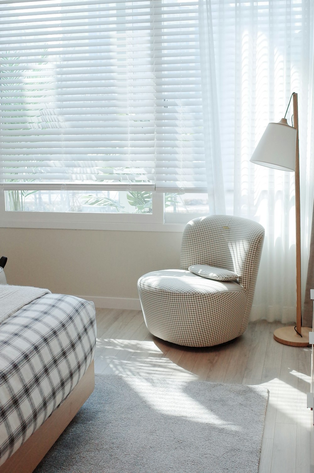 white and black plaid sofa chair near white window curtain