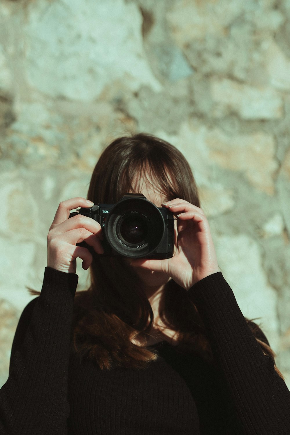 woman in black long sleeve shirt holding black camera