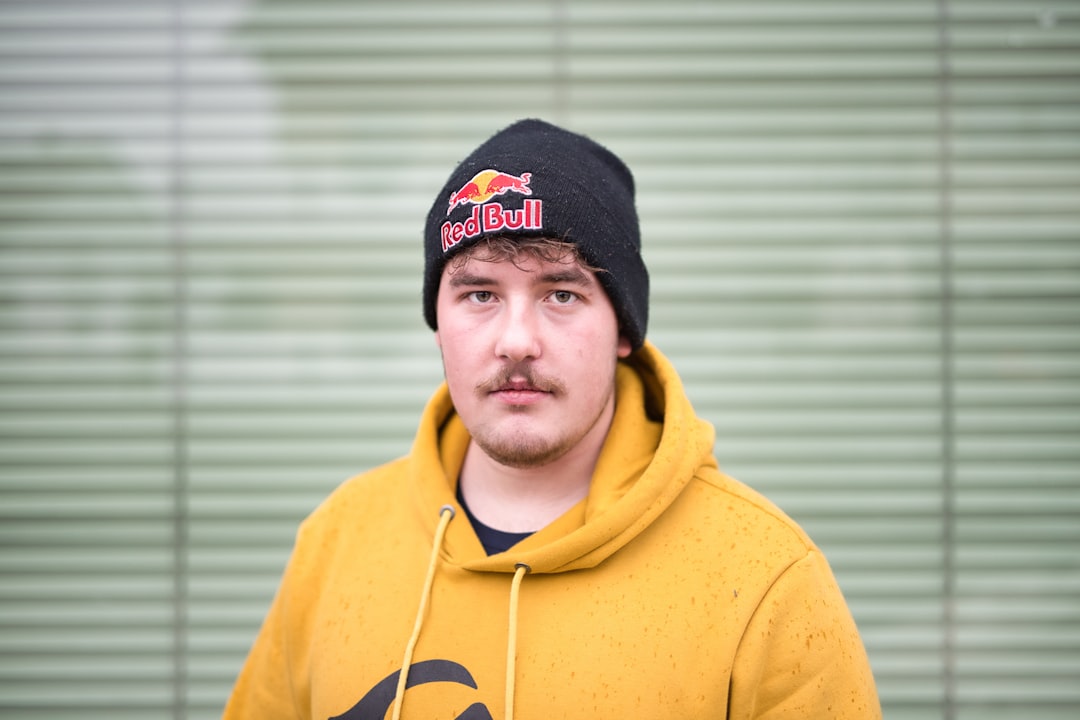 man in yellow hoodie wearing black knit cap