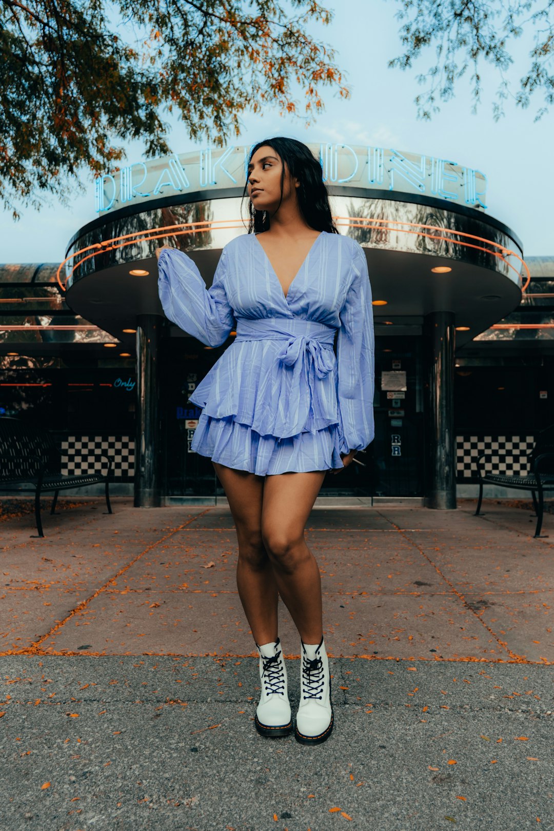 woman in blue dress standing on sidewalk during daytime