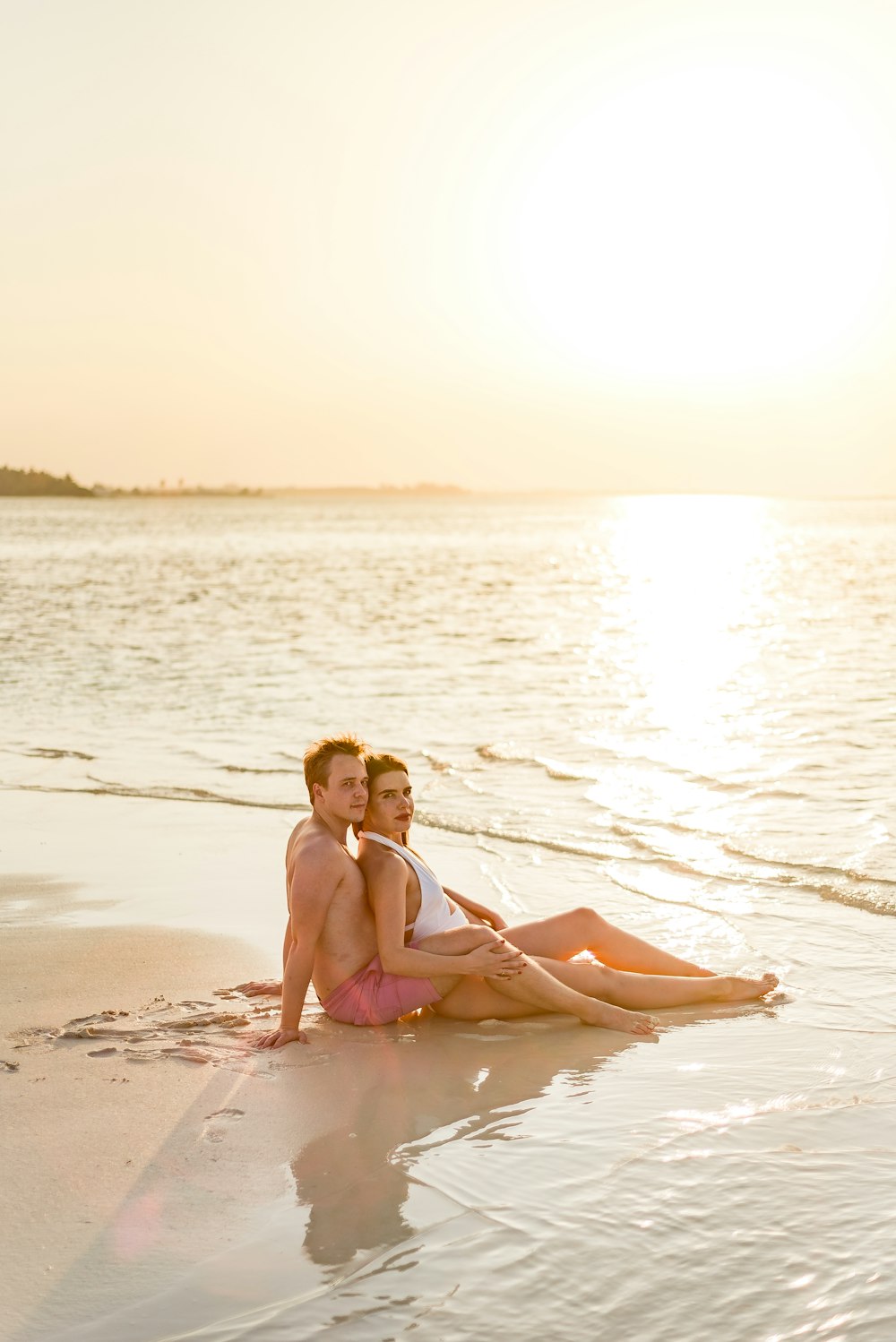 woman in pink bikini sitting on beach during daytime