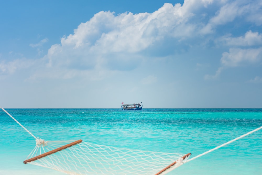 white and blue boat on sea under blue sky during daytime