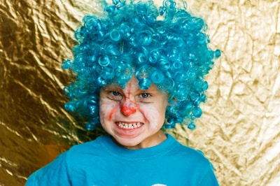 Children making silly faces with colorful props at a birthday party photo booth.