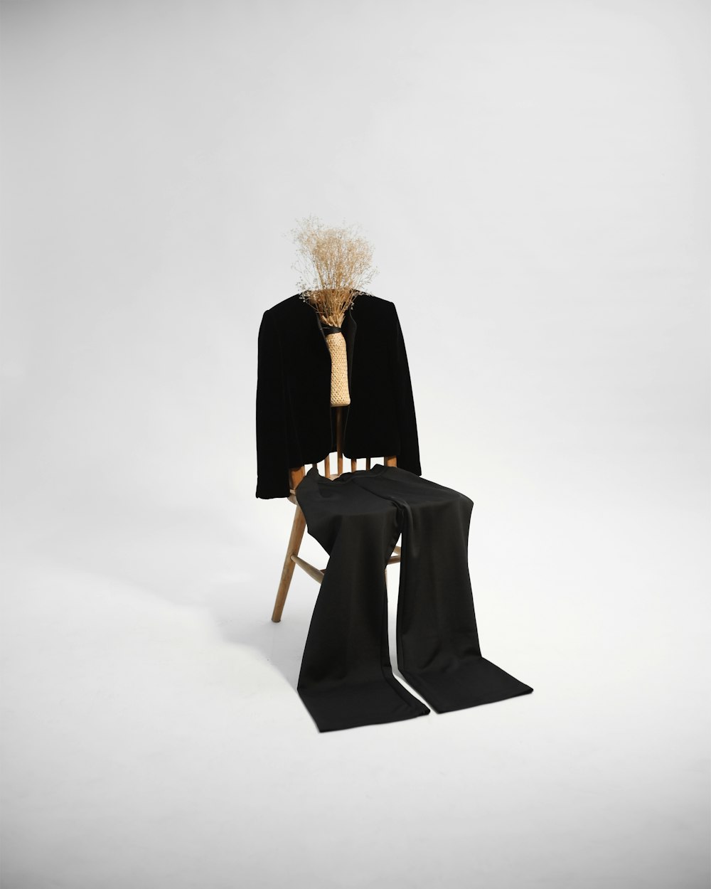 茶色の木製の椅子に座る黒いコートの女性