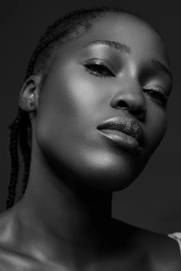 A minimalist, elegant black and white portrait of a confident woman with soft blush accents highlighting her serene expression.