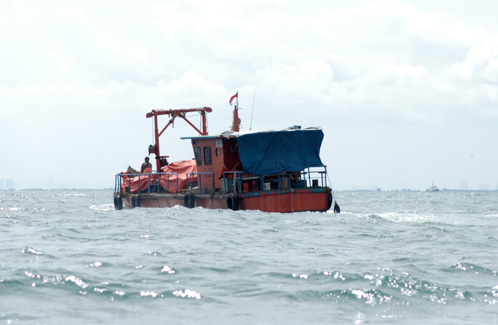 Barco rojo y negro en el mar durante el día