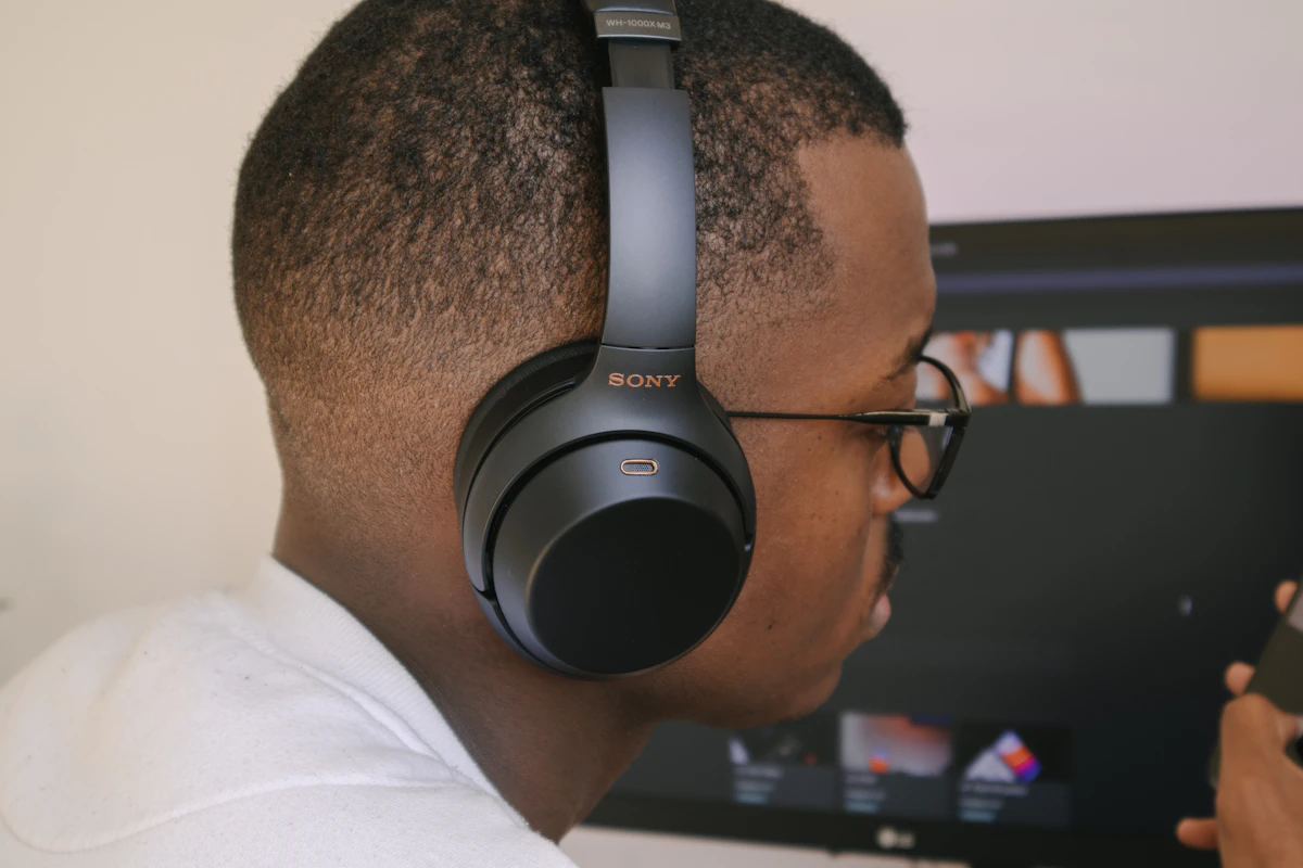 Person wearing the Sony WH-1000XM7 over-ear headphones while adaptive noise cancellation adjusts to a busy environment