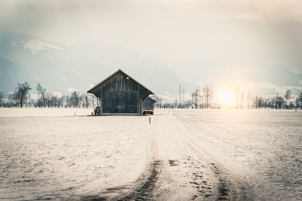 Braunes Holzhaus auf schneebedecktem Feld tagsüber