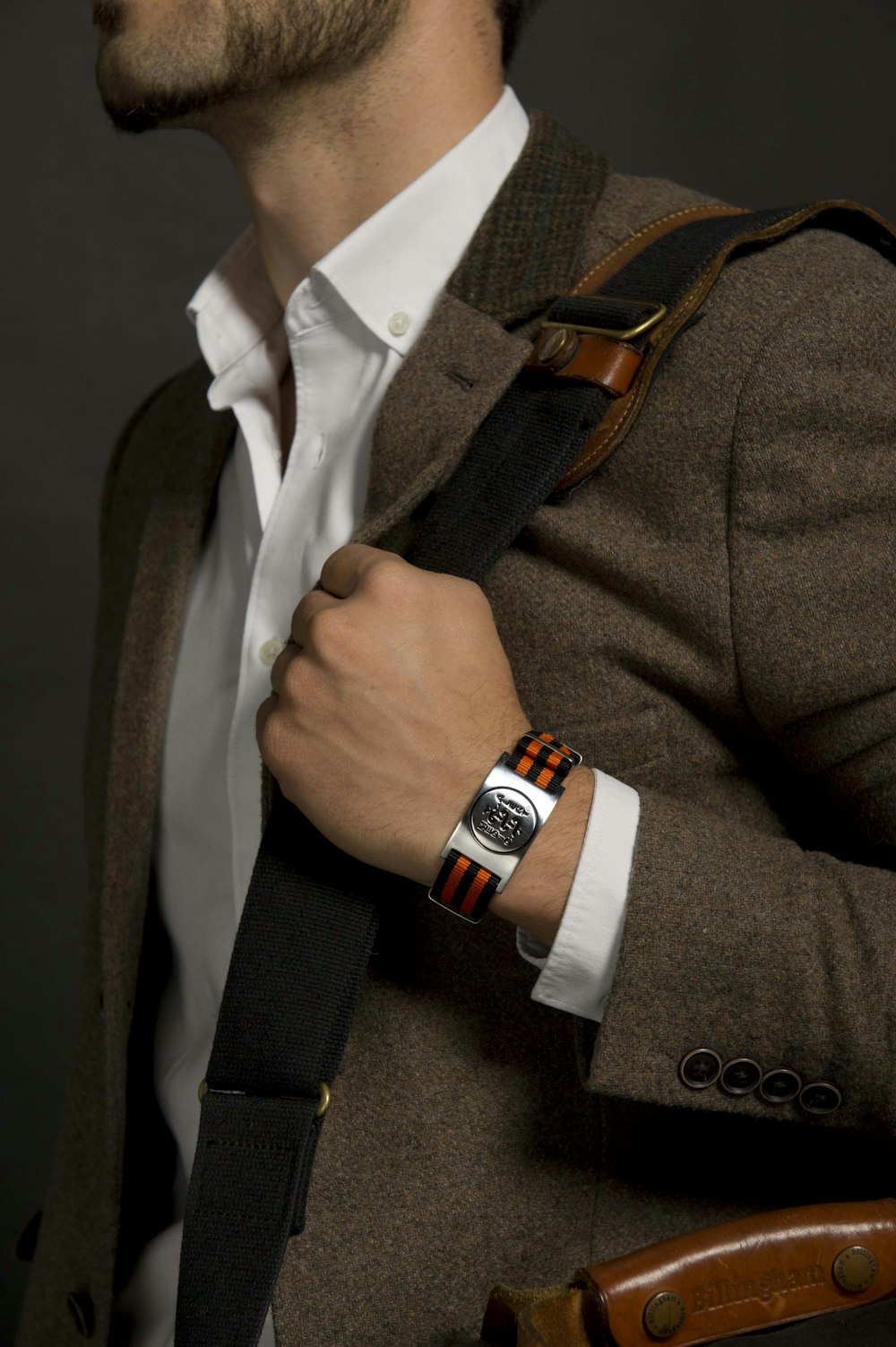 man in brown suit jacket wearing black and silver watch