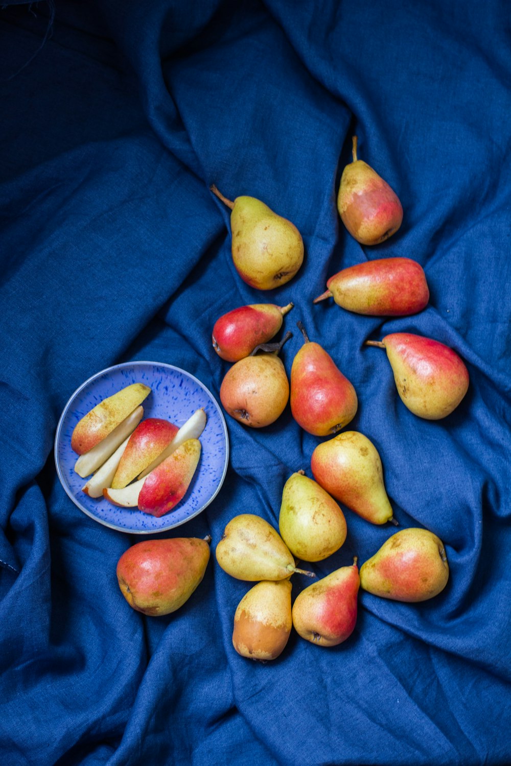 red and yellow round fruits on blue textile