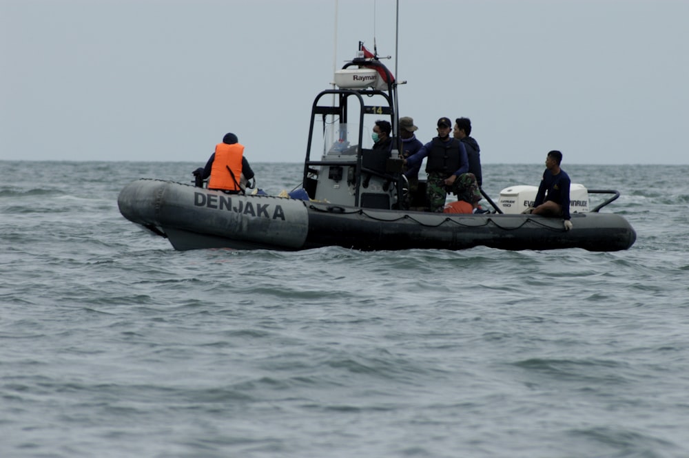 people riding on black inflatable boat during daytime