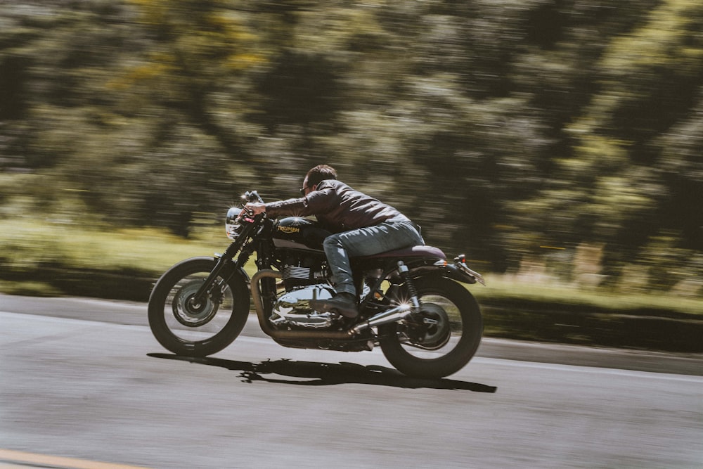 man in blue jacket riding black motorcycle on road during daytime