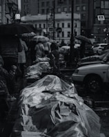 A rainy day scene with people holding umbrellas in a Thai city.