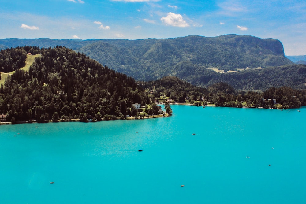 aerial view of green and brown mountains and body of water during daytime