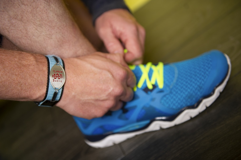 Person tying the laces of a blue training shoe