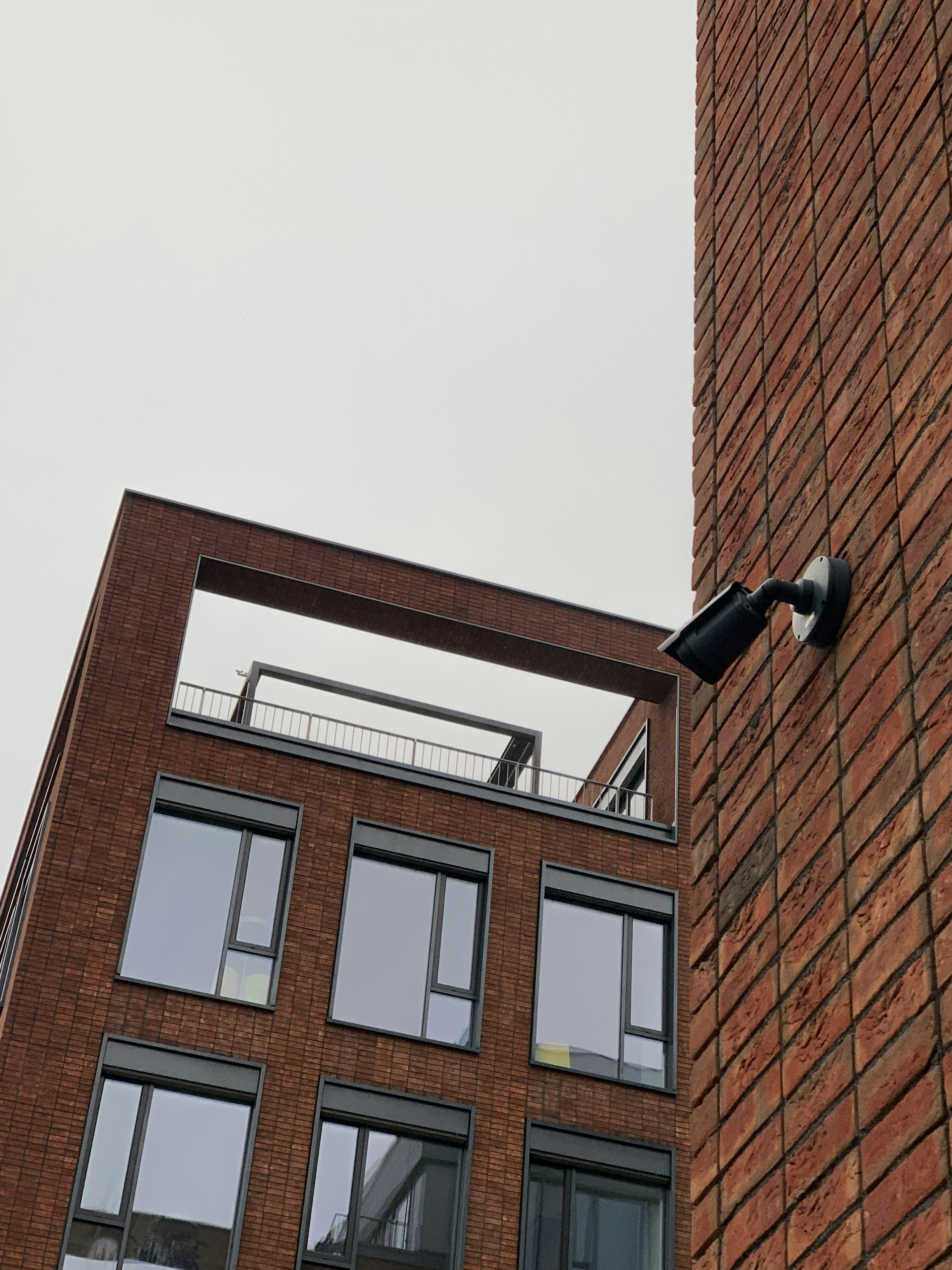 brown brick building with black and white wall lamp