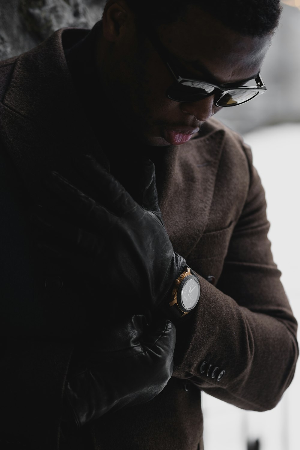 Mann im braunen Mantel mit schwarzer Sonnenbrille