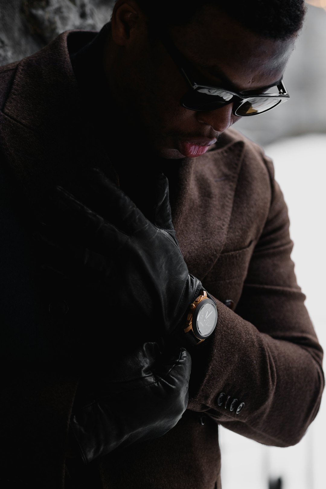 man in brown coat wearing black sunglasses