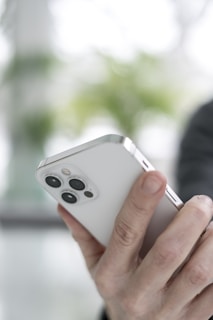 person holding silver apple remote