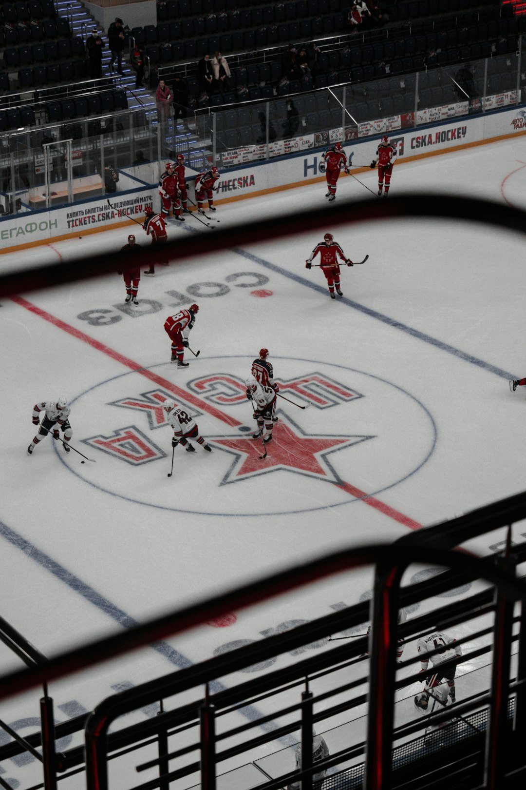 man in red and white jersey shirt riding on red and white hockey field