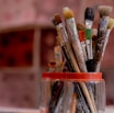 brown and red paint brush in clear glass container