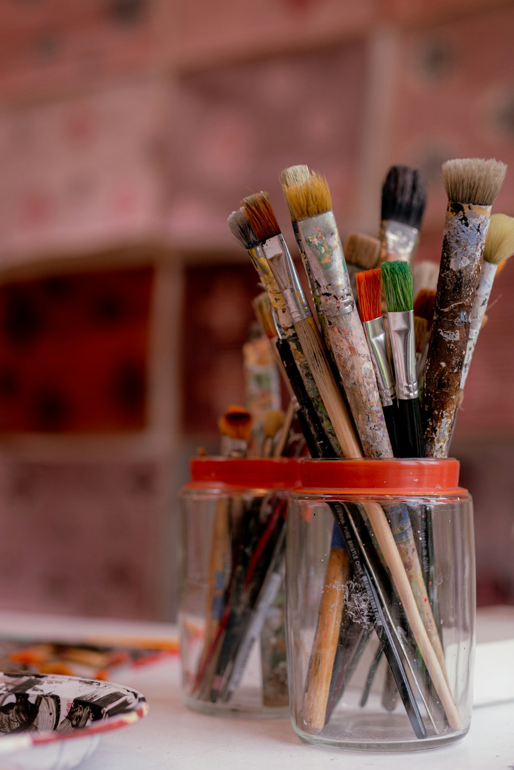 brown and red paint brush in clear glass container