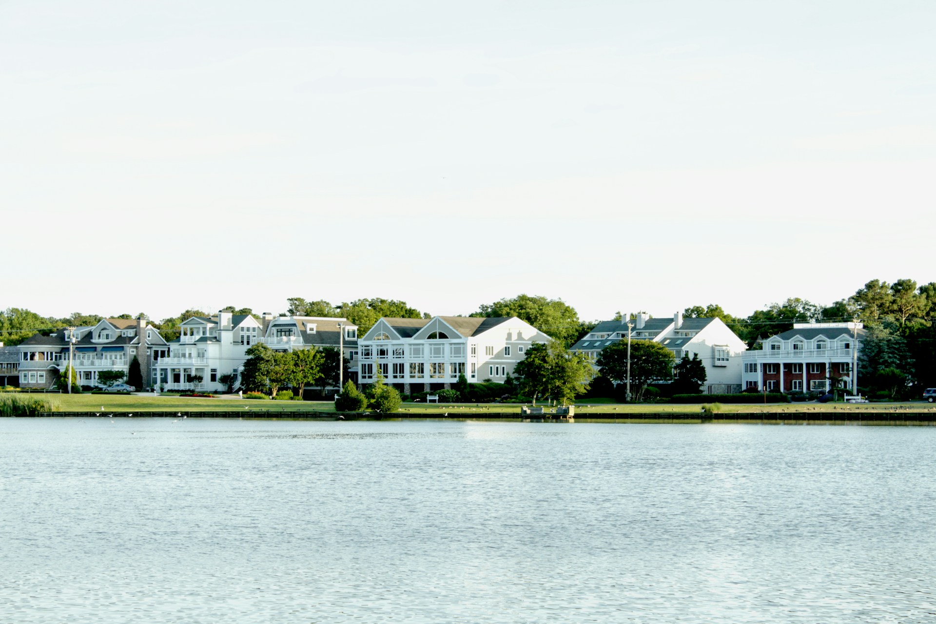 white and green house near body of water during daytime