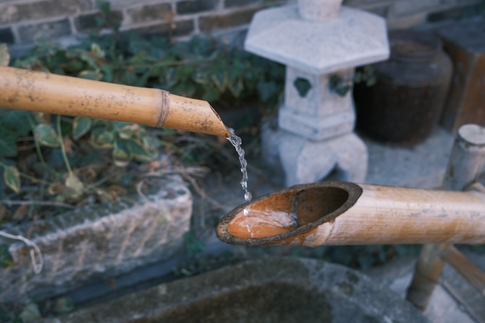 water pouring from brown wooden pipe