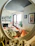 A cozy, bright living room with neatly organized shelves and soft natural light.
