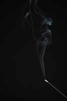 Aromatic incense sticks burning gently with wisps of smoke curling upwards