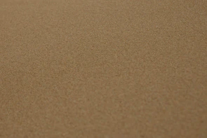 Coarse construction sand spread evenly on a flat surface ready for delivery.