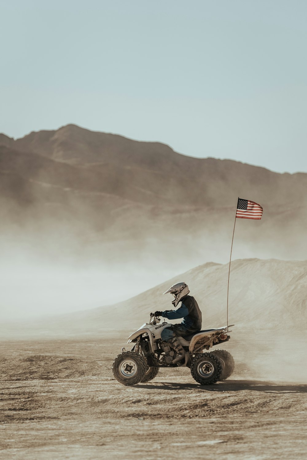 man riding atv on brown field during daytime