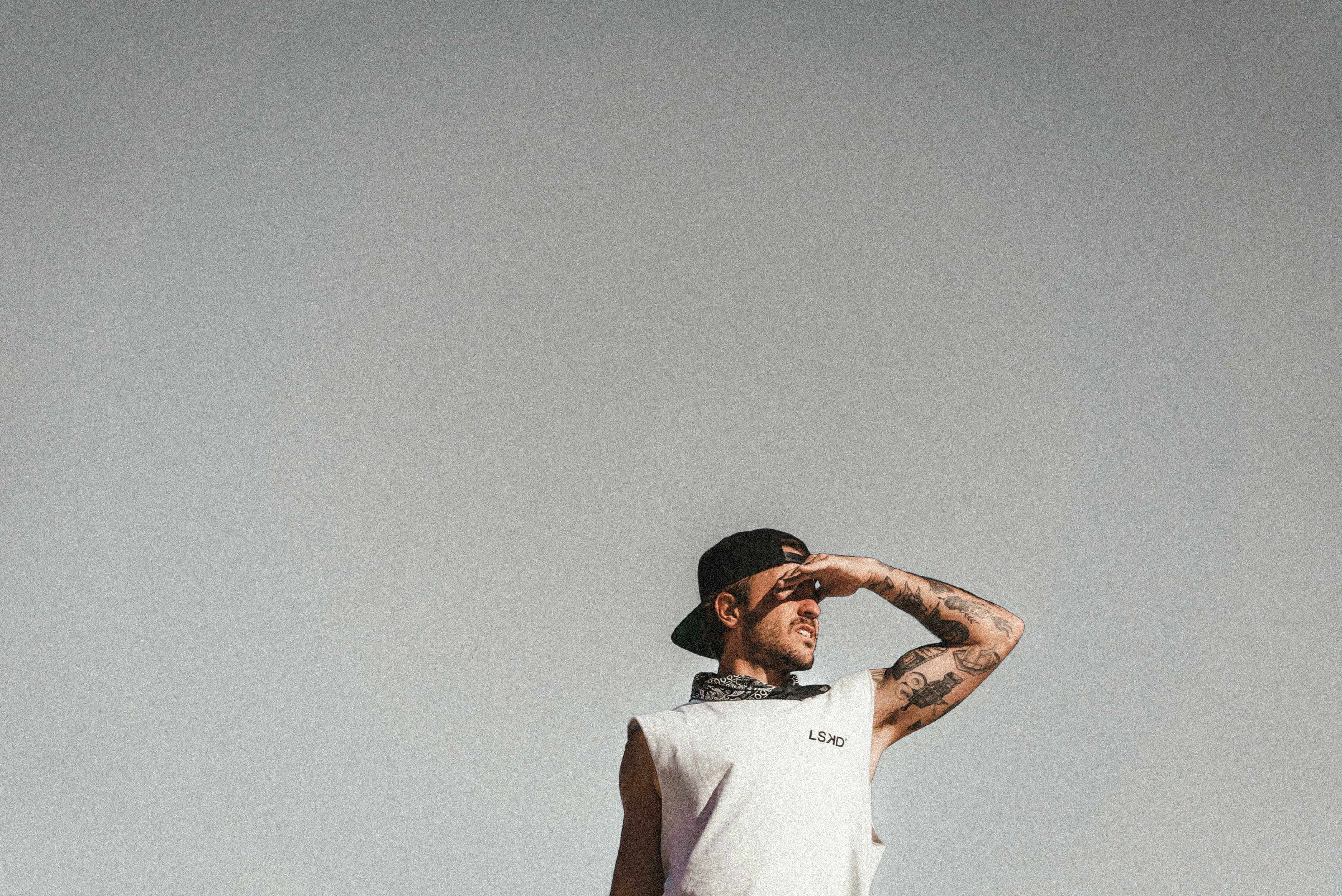 man in white t-shirt and black cap