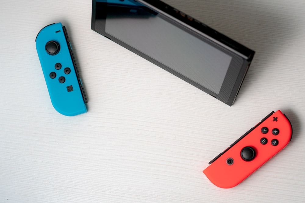 Nintendo Switch bleue à côté d’une tablette noire